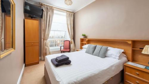 a bedroom with a bed and a chair and a window at Abbeyleigh House in Dublin