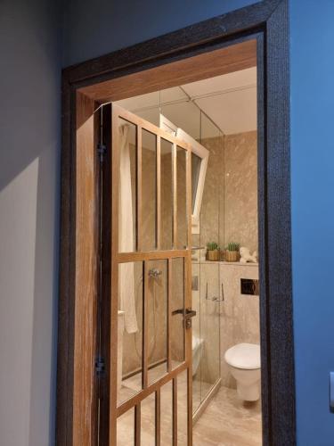 a bathroom with a toilet and a glass door at EXQUISITE GOLF VILLA with Sea, 8Tee, Green Views, in Aphrodite Hills Golf Resort in Kouklia