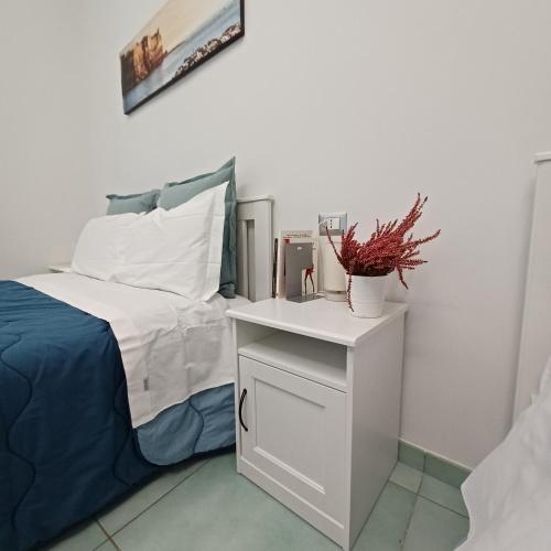 a bedroom with a bed and a white night stand at Casa Sassolini in Naples