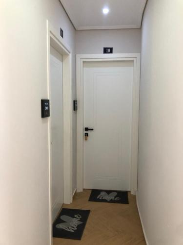 a hallway with a white door and a mirror at Villa Sarti in Ksamil