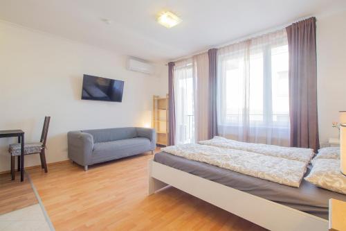 una camera con letto, divano e finestra di Corvin Modern Studio with AC, Smart TV a Budapest