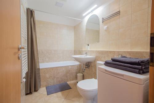 a bathroom with a toilet and a sink and a tub at Corvin Modern Studio with AC, Smart TV in Budapest