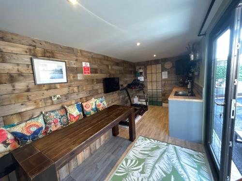 Eddies Lodge & Spa 3 bedroom cottage في Dungiven: غرفة بجدار خشبي مع مقعد