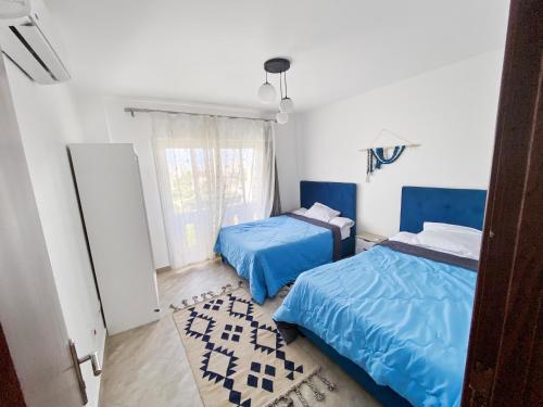 1 dormitorio con 2 camas y ventana en Your Go-to Place at Amwaj, North Coast for Summer!, en El Alamein