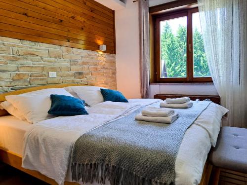 a bedroom with a large bed with towels on it at B&B Villa Plitvica in Plitvica Selo