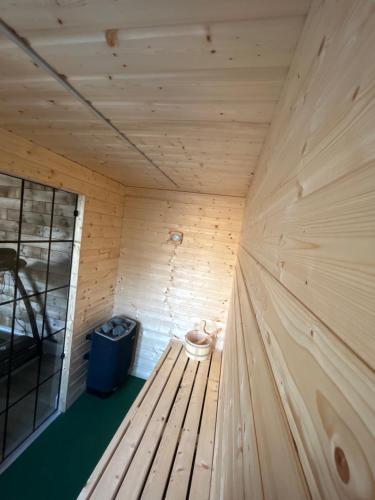 a wooden sauna with a bench and a trash can at Eddies Lodge & Spa 3 bedroom cottage in Dungiven