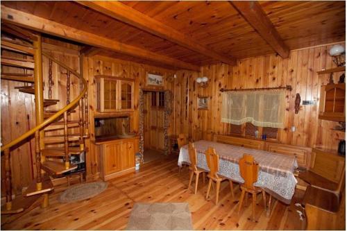 ein Esszimmer mit einem Tisch und Stühlen in einer Hütte in der Unterkunft Dowcień in Burdeniszki