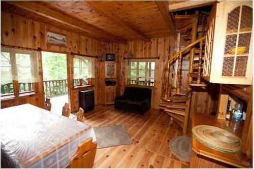 ein Schlafzimmer mit einem Bett in einer Holzhütte in der Unterkunft Dowcień in Burdeniszki