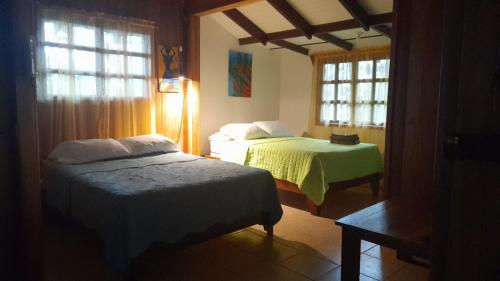 a bedroom with two beds and two windows at Las Brisas del Sur in Ojochal