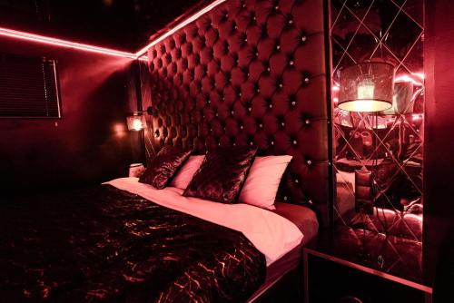Camera rossa con letto e testiera di Grey Secret Champagne Apartament Spa a Danzica