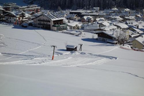 eine schneebedeckte Stadt mit Häusern im Hintergrund in der Unterkunft Hotel Habicht in Fulpmes
