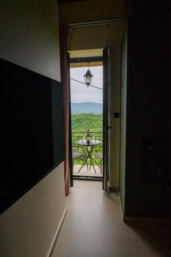 a hallway with a door open to a balcony with a table at The five keys in Monodendri