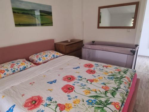 a bedroom with a bed with a floral comforter on it at Apartmani Bilić in Korenica