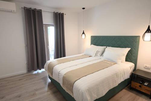 a bedroom with a large bed with a green headboard at Apartment Mina Dream in Jelsa