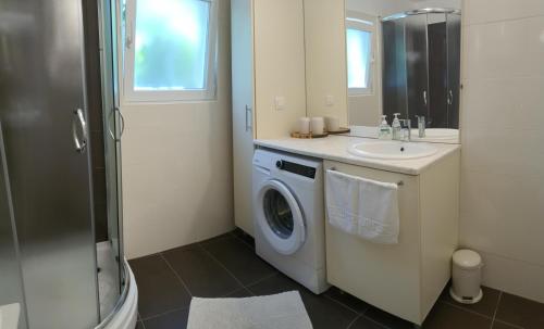 a bathroom with a washing machine and a sink at Kuća za odmor Žinžula in Medulin