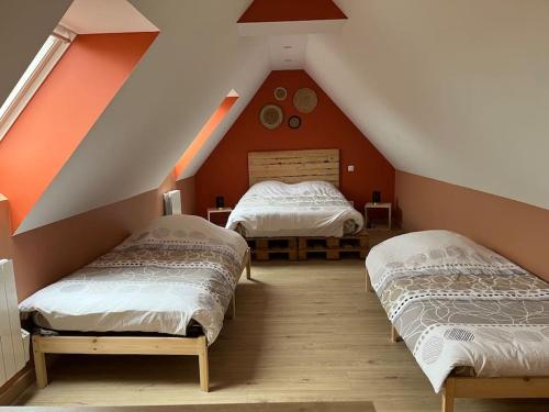 twee bedden in een kamer met een zolder bij Gite Le Long de l'eau in Long