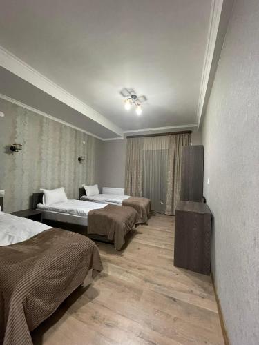 a hotel room with two beds and a television at Hotel Shina in Kazbegi