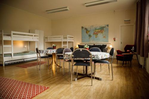 Cette chambre comprend une table, des chaises et des lits superposés. dans l'établissement Kalvs Skolhus, à Kalv