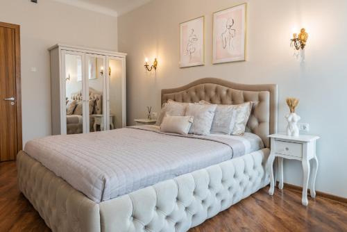 een slaapkamer met een groot bed met een witte sprei bij E. D. Angel Wing Apartment in Šiauliai