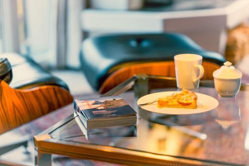 a plate of food on a glass table with a cup of coffee at Casa Nonna in Lenzerheide