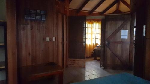 a room with wooden walls and a door and a bedroom at Las Brisas del Sur in Ojochal