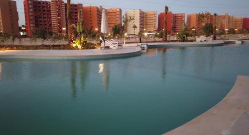 un grand bassin d'eau avec des bâtiments en arrière-plan dans l'établissement Cozy studio Porto golf, à El Alamein