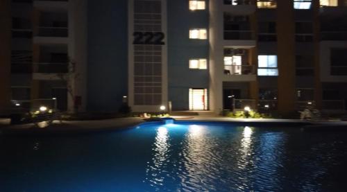 a swimming pool at night with buildings in the background at Cozy studio Porto golf in El Alamein