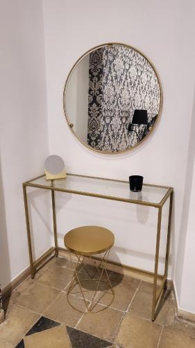 a glass table with a mirror and a stool at Domus Mia in Tivoli