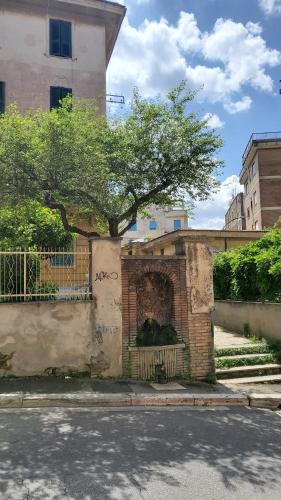 a brick wall with a tree next to a building at Domus Mia in Tivoli