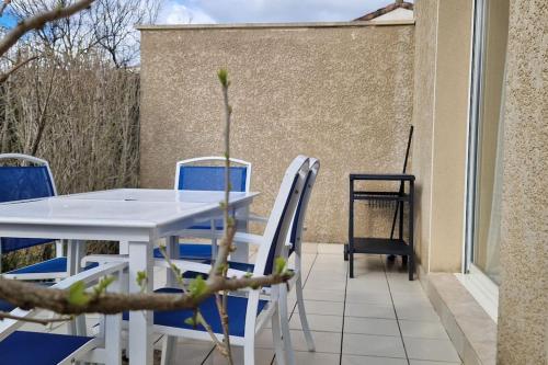 una mesa y sillas en un patio con una planta en Les faïsses ardèchoises en Salavas