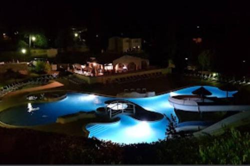 un parque acuático por la noche con un barco. en Les faïsses ardèchoises en Salavas