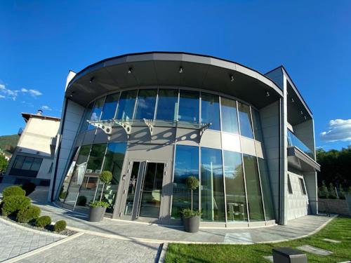 a large glass building with a revolving door at da C I S A in Tambre dʼAlpago