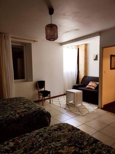 a hotel room with two beds and a couch at Gîte La Petite Longère in Septfonds