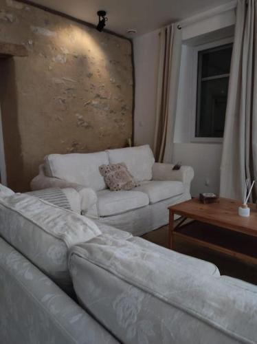 a living room with a white couch and a table at Gîte La Petite Longère in Septfonds
