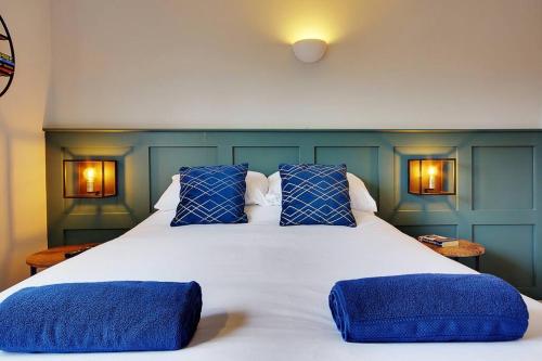 a bedroom with a large white bed with blue pillows at Bright and Cosy house with 3 bedroom 3 bathrooms in Bournemouth