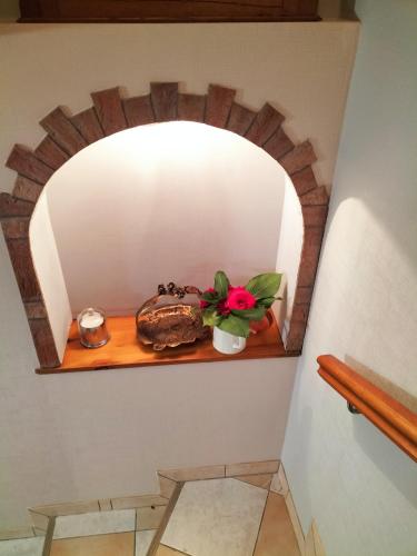 a room with a shelf with a flower on it at Les capucines la souris des champs in Étival-Clairefontaine