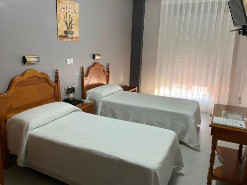 a hotel room with two beds and a window at Hotel Lusitania, Centro Ciudad, Parking Privado in Merida
