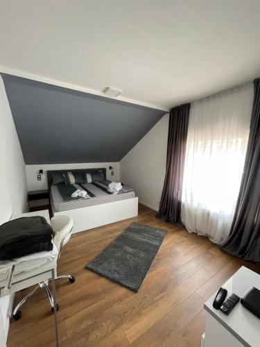 a bedroom with a bed and a desk and a window at Villa Luca in Sarajevo