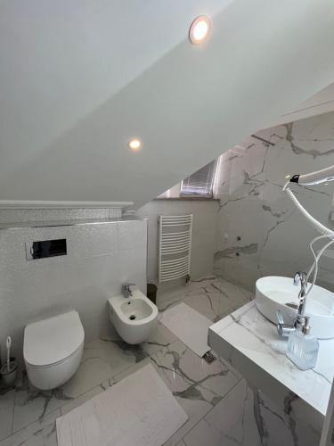 a white bathroom with a toilet and a sink at Villa Luca in Sarajevo