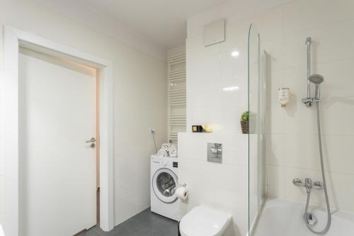 a bathroom with a toilet and a washing machine at Golden Apartments Warsaw - Big and Bright Stylish Apartments - City Center - Pereca in Warsaw