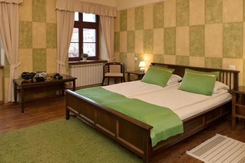 a bedroom with a large bed with green pillows at La Fresca in Kroměříž