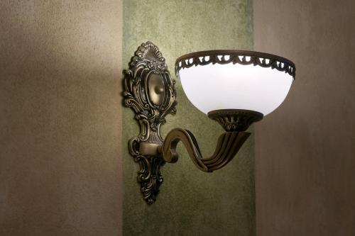 a wall light with a mirror on a wall at La Fresca in Kroměříž
