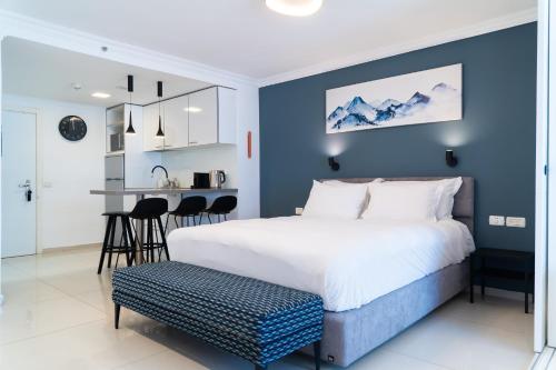 a bedroom with a large bed with a blue wall at Beachfront Boutique Apartment in Herzliya