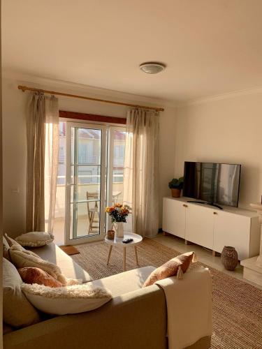a living room with a couch and a tv at Nalu House Baleal - by the beach in Baleal