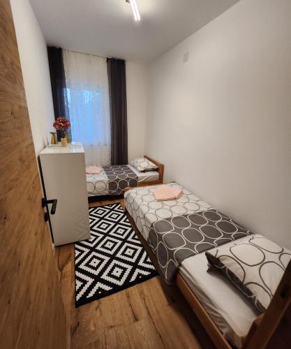 a room with two beds and a refrigerator in it at Apartman Lidija in Starigrad