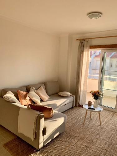 a living room with a couch and a table at Nalu House Baleal - by the beach in Baleal