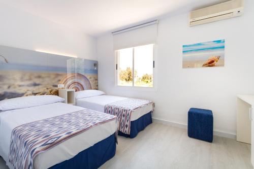 a bedroom with two beds and a window at Jutlandia Family Resort in Santa Ponsa