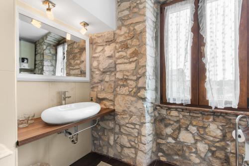 a stone bathroom with a sink and a window at Villa San Vincenti in Svetvinčenat