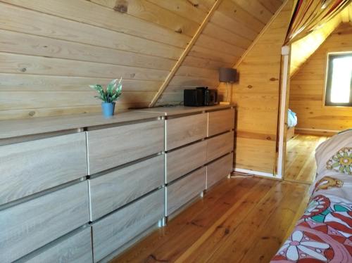 a room with wooden walls and wooden flooring in a log cabin at Arkadia Domki in Dziwnów