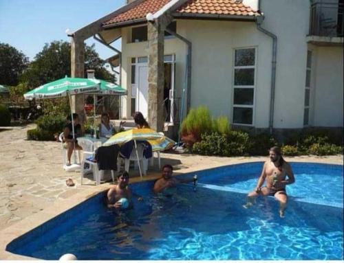 a group of people sitting in a swimming pool at Guest House Plamena in Krapets